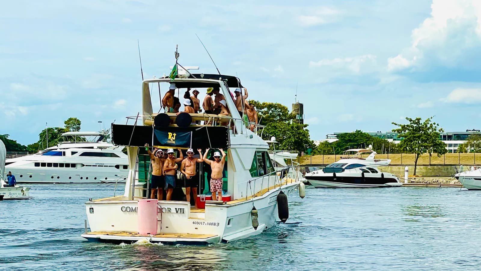 Grupo comemorando a bordo com a bandeira da RJFiestas na Marina da Glória
